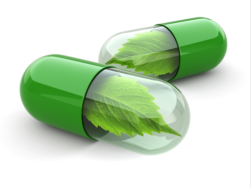 green food supplements capsules with leaves inside